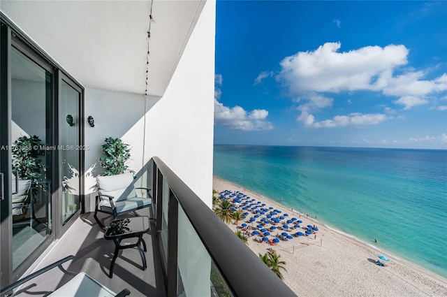 balcony featuring a water view and a beach view