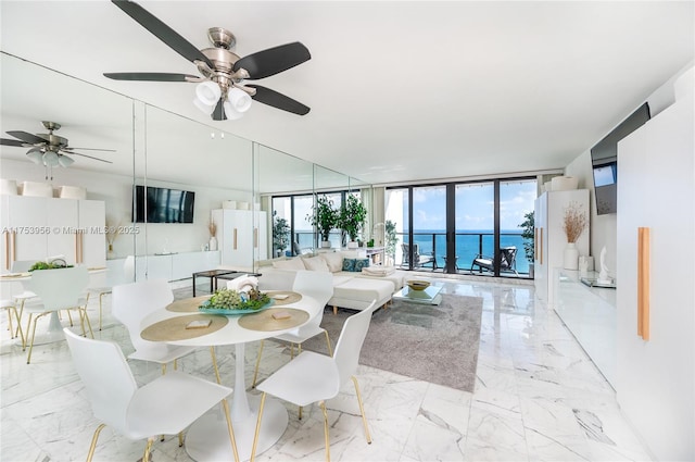 dining space featuring expansive windows, marble finish floor, and a healthy amount of sunlight