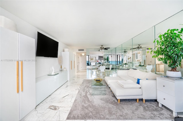 unfurnished living room with visible vents, marble finish floor, and a ceiling fan