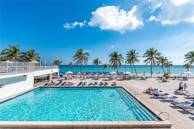 community pool with a patio and a water view