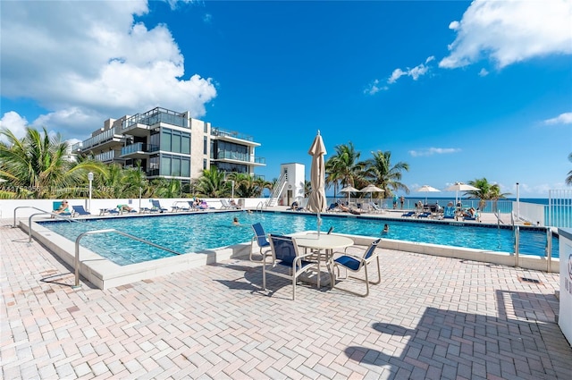 community pool with a patio and fence