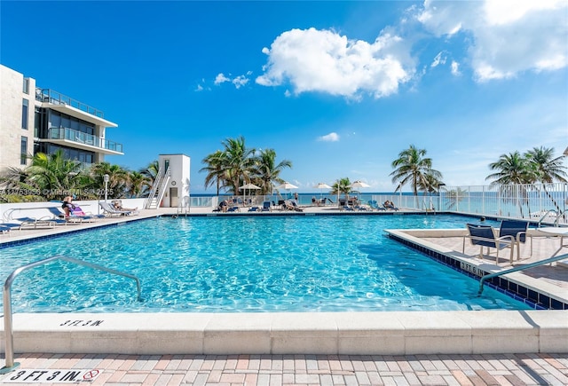 pool with a patio area and fence