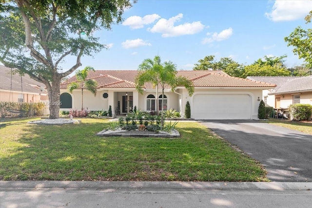 mediterranean / spanish house featuring a garage, stucco siding, aphalt driveway, and a front yard