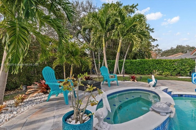 view of pool featuring a patio and an in ground hot tub