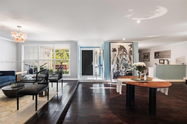 foyer with ornamental molding, baseboards, an inviting chandelier, and wood finished floors