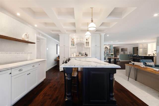 kitchen featuring white cabinets, coffered ceiling, dark wood finished floors, and light stone countertops