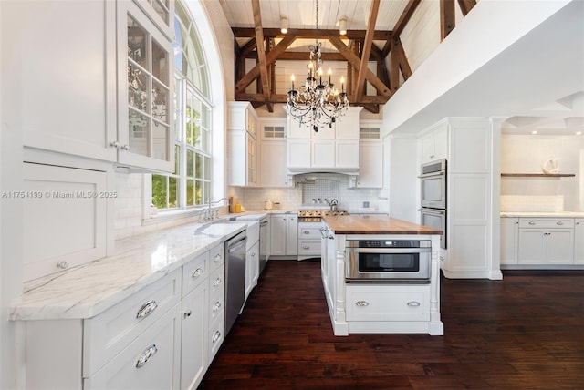 kitchen featuring stainless steel appliances, butcher block counters, and white cabinetry