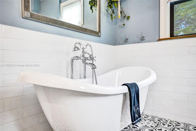 full bathroom featuring a wainscoted wall, a freestanding bath, tile walls, and a wealth of natural light