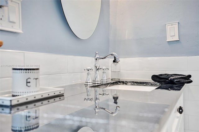 bathroom featuring a sink and tile walls