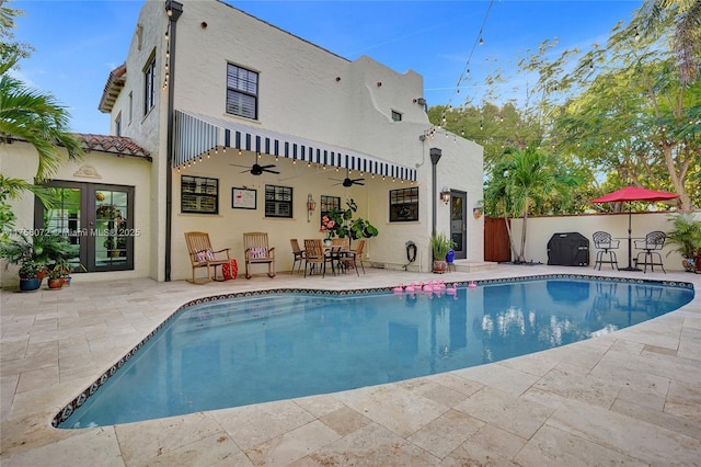 outdoor pool with a ceiling fan, french doors, and a patio area