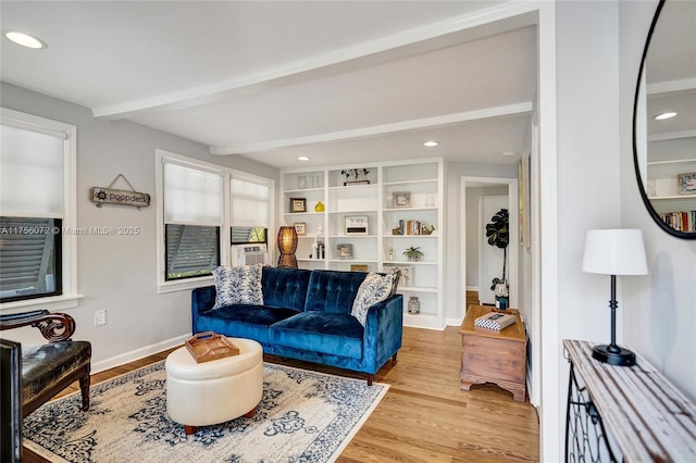 living area featuring recessed lighting, beamed ceiling, baseboards, and wood finished floors