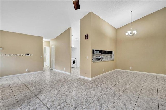 unfurnished living room featuring washer / dryer, lofted ceiling, baseboards, and an inviting chandelier