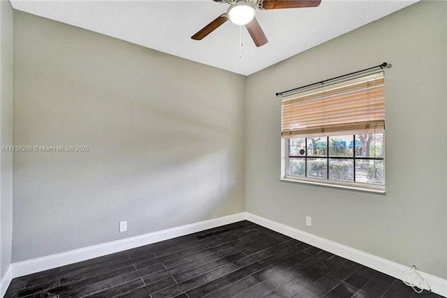 empty room featuring dark wood-style flooring, a ceiling fan, and baseboards