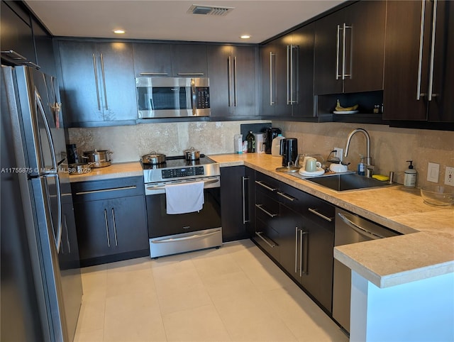 kitchen with light countertops, appliances with stainless steel finishes, a sink, and visible vents