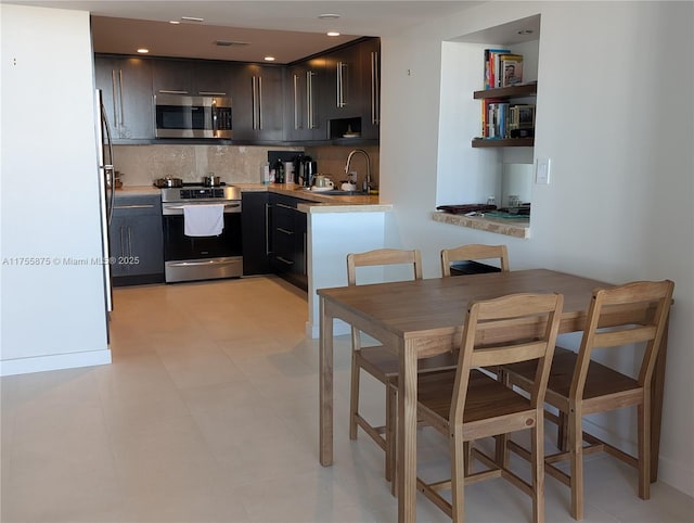 kitchen featuring stainless steel appliances, a sink, visible vents, light countertops, and backsplash