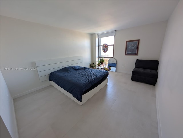 bedroom featuring a wall of windows and baseboards