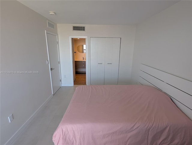 unfurnished bedroom featuring a closet, visible vents, baseboards, and ensuite bathroom