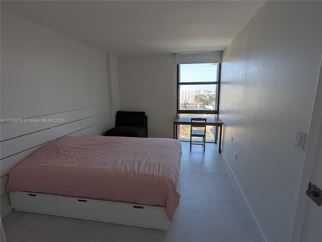 bedroom with baseboards and a wall of windows