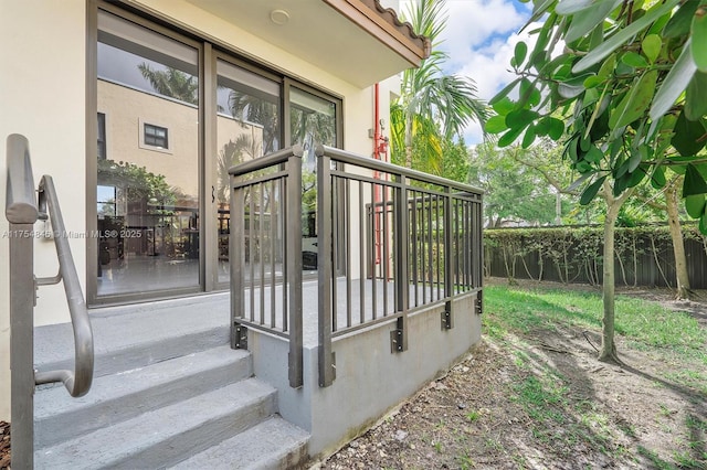 doorway to property with fence and stucco siding