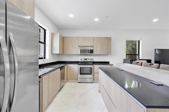 kitchen featuring appliances with stainless steel finishes, modern cabinets, marble finish floor, and light brown cabinetry