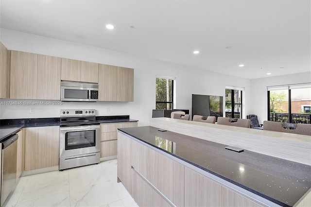 kitchen with modern cabinets, stainless steel appliances, and light brown cabinetry