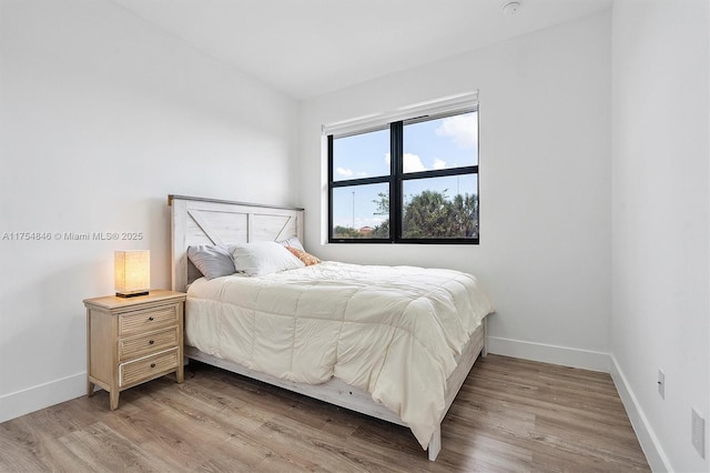 bedroom with light wood-type flooring and baseboards