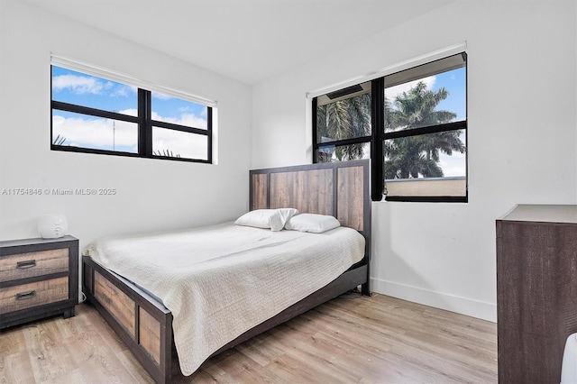 bedroom with light wood-style floors and baseboards