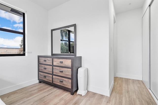 bedroom featuring a closet, light wood-type flooring, and baseboards