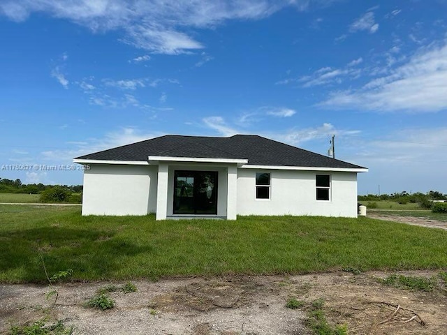 rear view of property with a yard and stucco siding