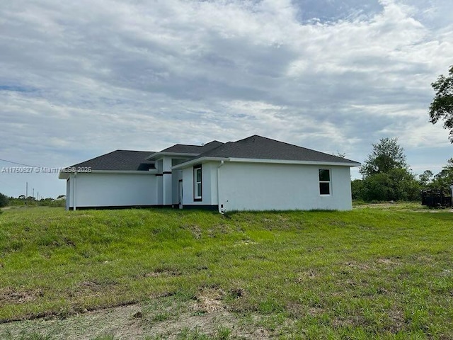 view of side of property with a lawn and stucco siding