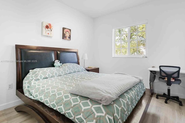 bedroom with baseboards and wood finished floors