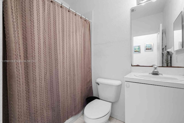 full bathroom featuring toilet, tile patterned flooring, and vanity