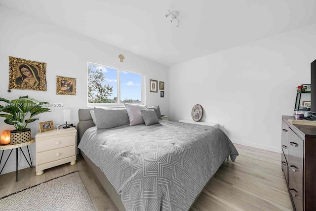 bedroom with light wood finished floors and baseboards