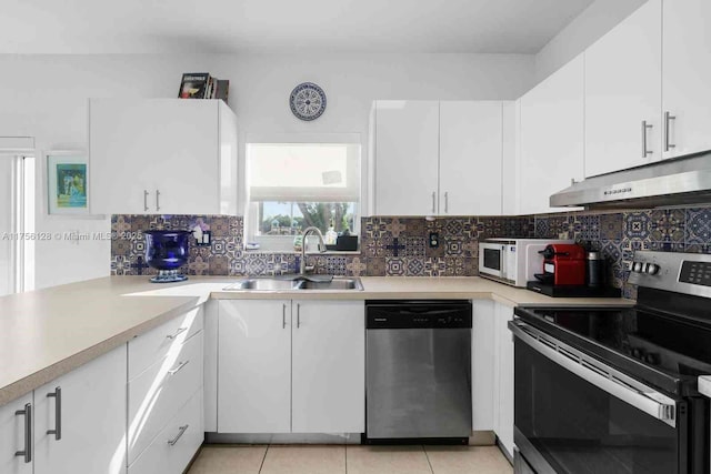 kitchen featuring appliances with stainless steel finishes, a sink, light countertops, under cabinet range hood, and backsplash