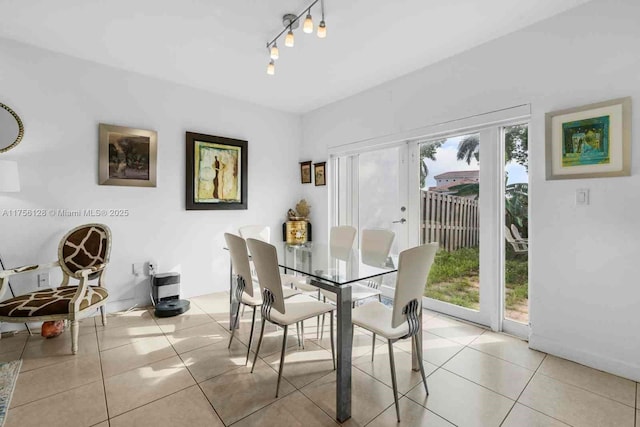 dining area with light tile patterned floors, rail lighting, and a wealth of natural light