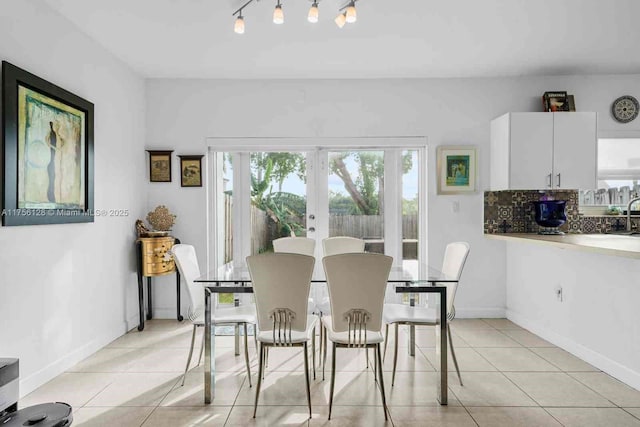 dining room featuring french doors, light tile patterned flooring, and baseboards