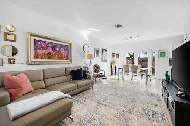 tiled living room featuring rail lighting and visible vents