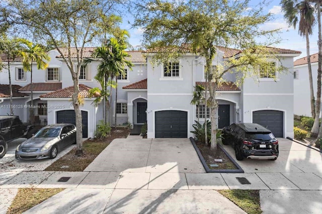 mediterranean / spanish house with a tile roof, driveway, and stucco siding