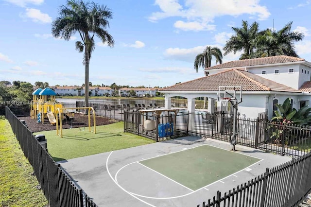 view of sport court with playground community, a lawn, fence, and community basketball court