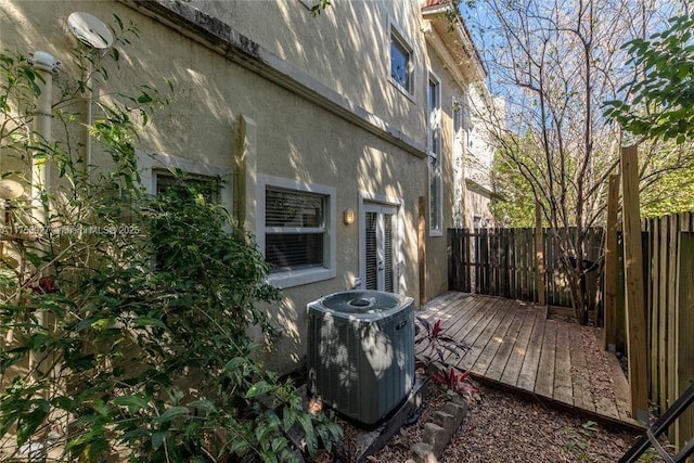 exterior space with fence and central AC unit