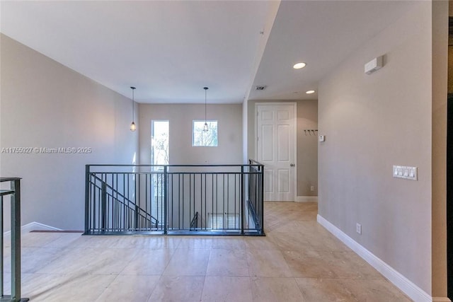 hallway featuring recessed lighting, baseboards, and an upstairs landing