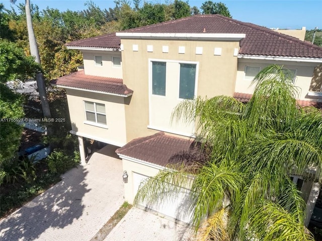 view of front of property with driveway, a tile roof, and stucco siding