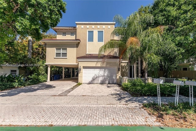 view of front of property with decorative driveway, stucco siding, a garage, a carport, and a tiled roof