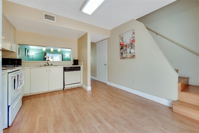 kitchen featuring visible vents, electric stove, dishwasher, light countertops, and a sink