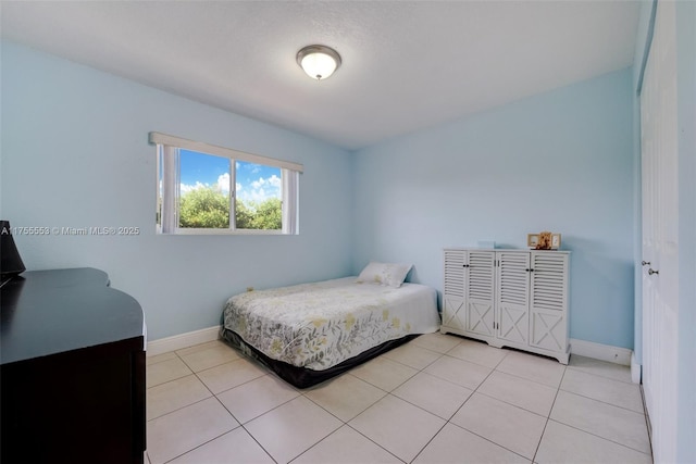 bedroom with baseboards and light tile patterned flooring