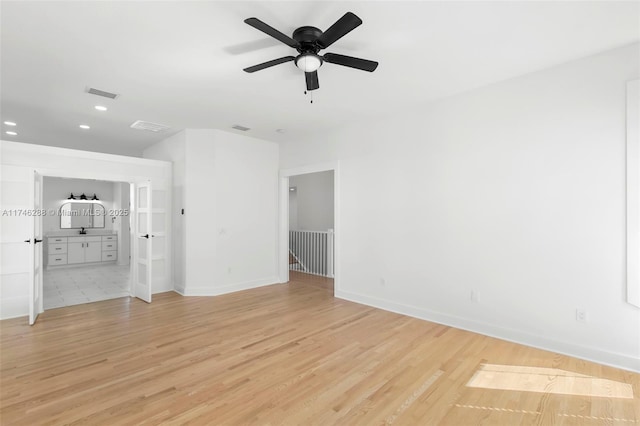 spare room featuring light wood-type flooring, visible vents, baseboards, and recessed lighting