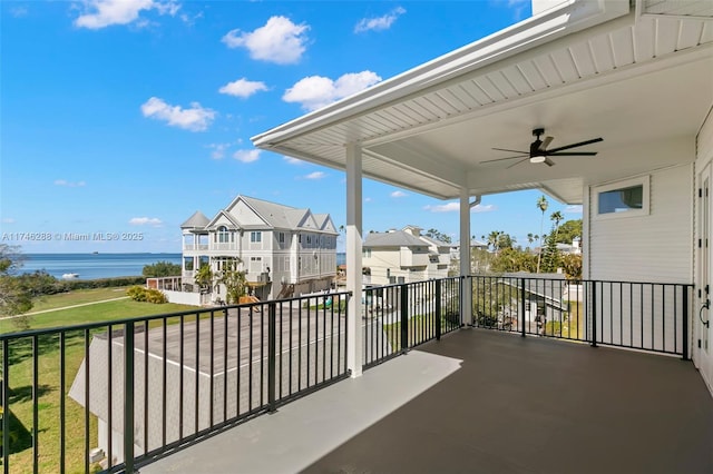 balcony featuring a water view and ceiling fan