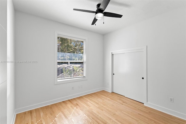 unfurnished room featuring light wood-style floors, baseboards, and a ceiling fan