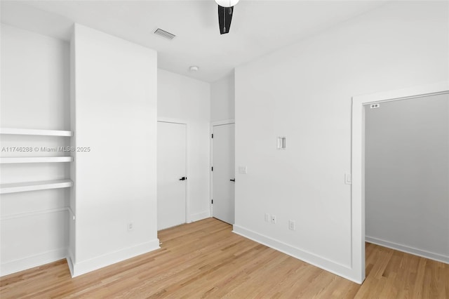 unfurnished bedroom with light wood-style floors, visible vents, baseboards, and a ceiling fan