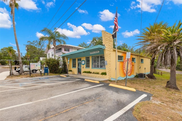 view of property featuring uncovered parking and central AC unit